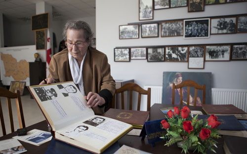 Nineli Andriadze, caretaker of Missing Persons Museum in Tbilisi, shows album of missing persons. Photo: George Gogua