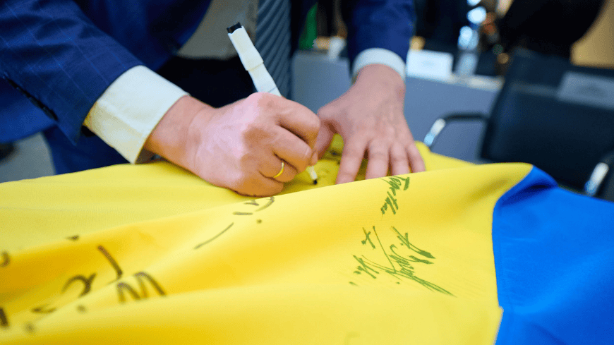 Signature du drapeau ukrainien lors de la cérémonie de clôture de la cinquième session du dialogue de haut niveau à Strasbourg