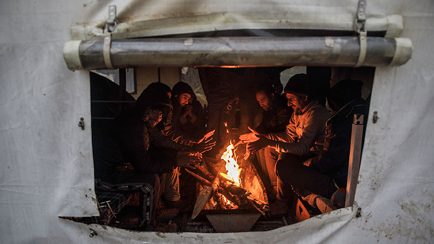 Migrants warm themselves by the fire set in one of the tents in Vucjak camp, 25 November 2019, © Damir Sagolj / Council of Europe Commissioner for Human Rights
