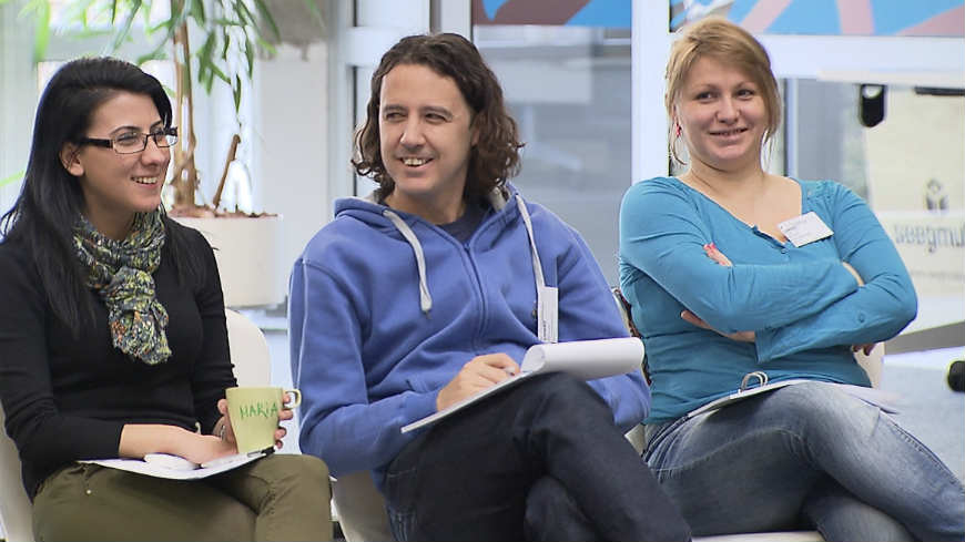 3 young people sitting on chairs smiling, participants at one of the EYF seminars held